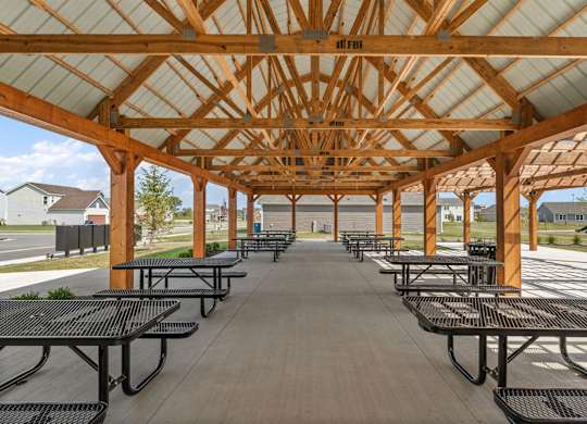 A wooden pavilion with black benches is shown.