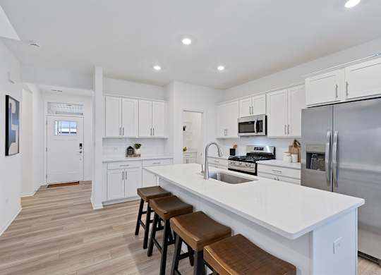 A modern kitchen with white cabinets and stainless steel appliances.