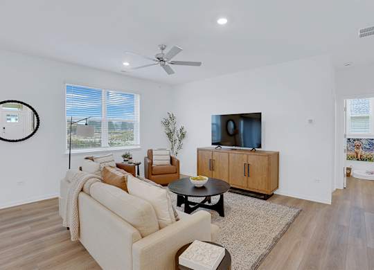 A living room with a couch, a coffee table, and a television.