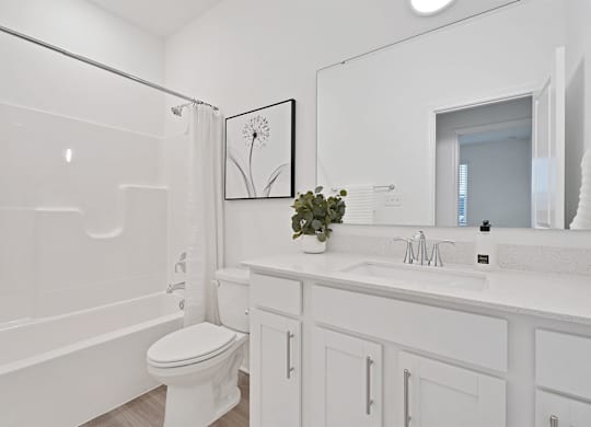 A white bathroom with a toilet, sink, and bathtub.
