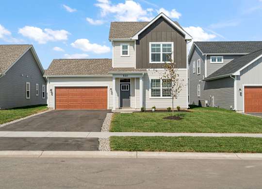 A house with a grey roof and a brown garage door.