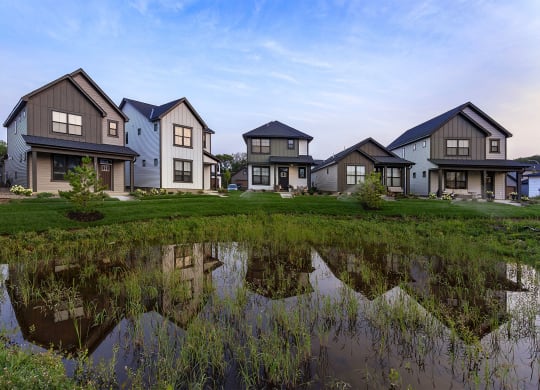 a group of houses reflected in a puddle of water