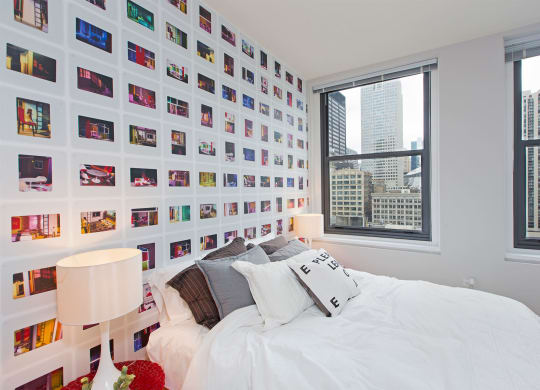 a bedroom with a bed and a wall covered in photos