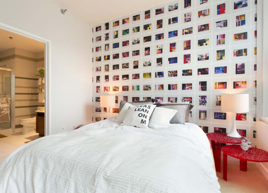 a bedroom with a bed and a wall of photos