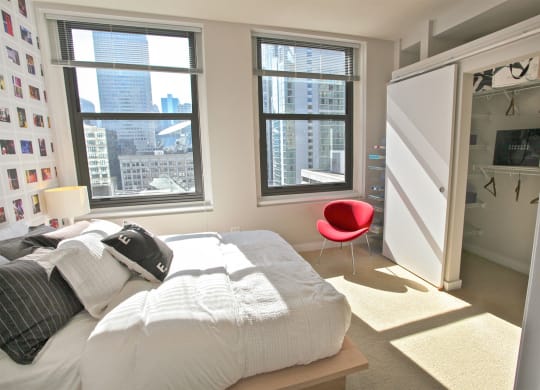 a bedroom with a bed and a closet and three windows