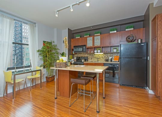 a kitchen with a large island and a stainless steel refrigerator