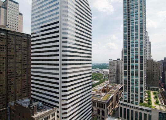 two tall skyscrapers with a city in the background