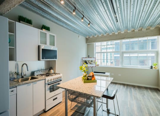 a kitchen with white appliances and a table and a window
