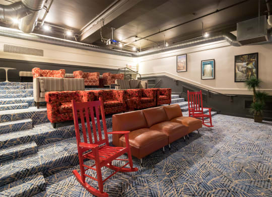 a large room with red chairs and couches and a seating area