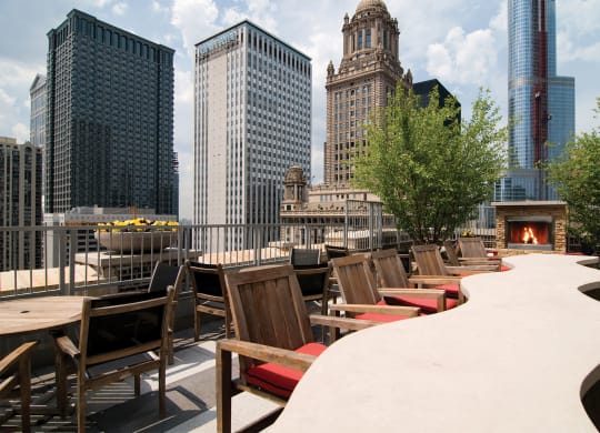 a rooftop patio with tables and chairs and a fire pit