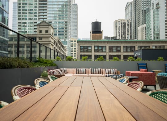 a communal table on a balcony in a city with tall buildings