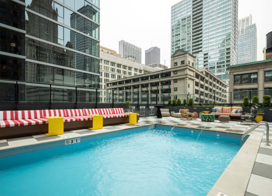 a swimming pool on the rooftop of a building with skyscrapers