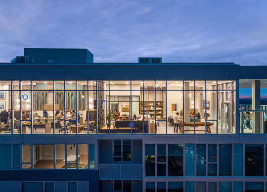 a view of a building with glass windows at dusk