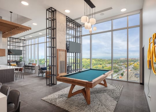 a clubhouse with a pool table and a view of the city