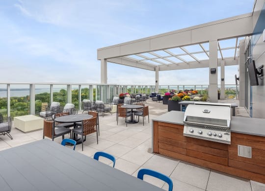 a terrace with tables and chairs and a grill