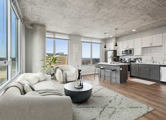 A modern living room with a grey couch and a round table.