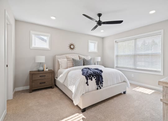a bedroom with a bed and a ceiling fan