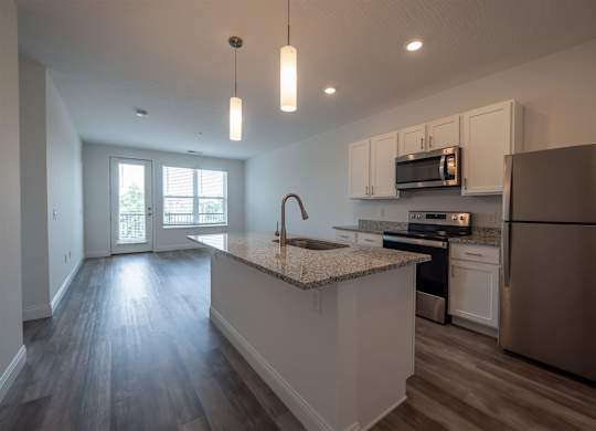 A kitchen with a granite countertop and stainless steel appliances.