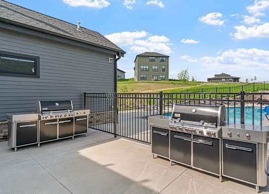 A backyard with a grill and a pool.