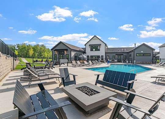 A sunny day at the pool with a fire pit in the middle.