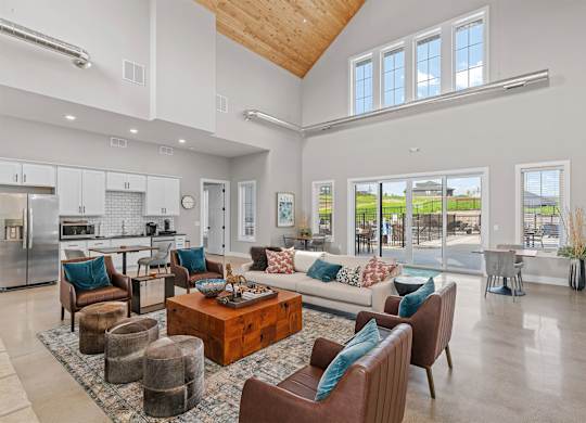 A spacious living room with a kitchen in the background.
