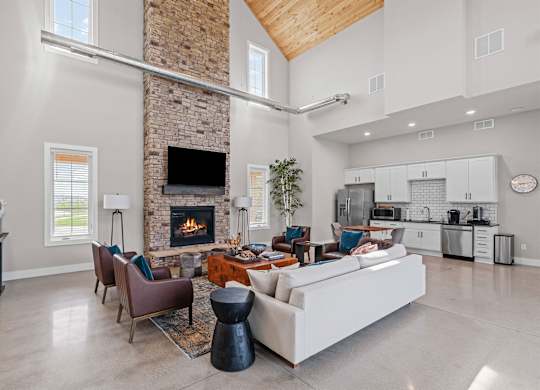 A modern living room with a stone fireplace and a large sectional sofa.
