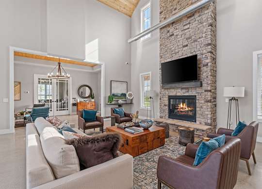 A living room with a stone fireplace and a large couch.