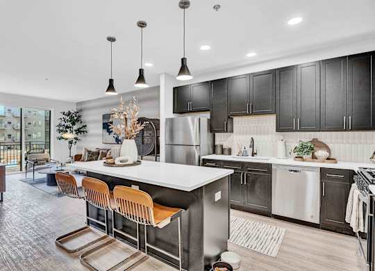 A modern kitchen with a long island and bar stools.
