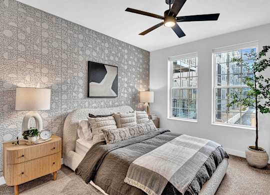 A bedroom with a bed, nightstand, and a ceiling fan.