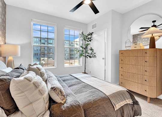 A bedroom with a large bed and a ceiling fan.