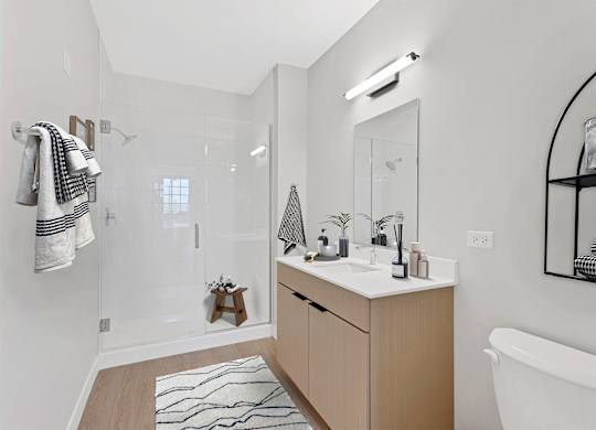 A bathroom with a white tub, sink, and a mirror.