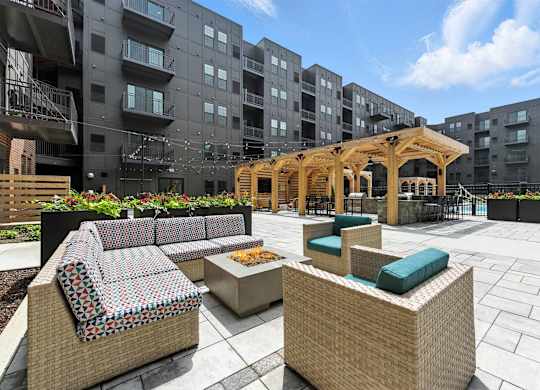 A patio area with a woven bench and a wooden pergola.
