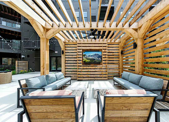 A wooden patio with a couch and chairs.