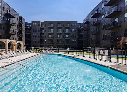 A swimming pool in front of apartment buildings.