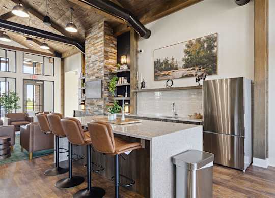 A kitchen with a bar area and a refrigerator.