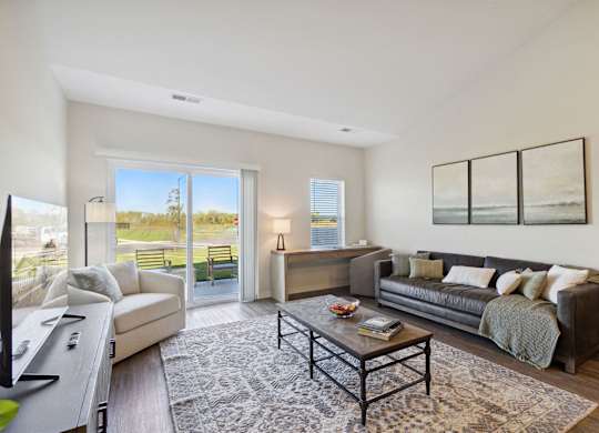 A living room with a couch, a coffee table, and a television.