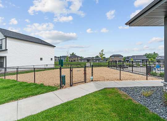 A white house with a black roof and a black fence.