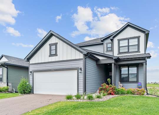 A modern house with a grey exterior and a white garage door.