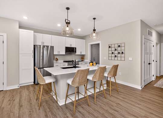 A kitchen with a white island and chairs.