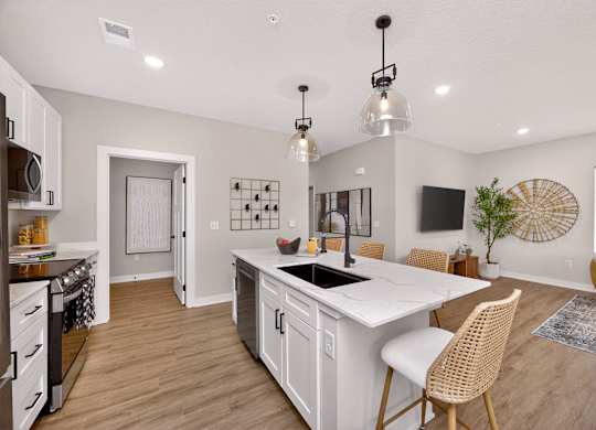 A kitchen with a white island and a dining table with chairs.