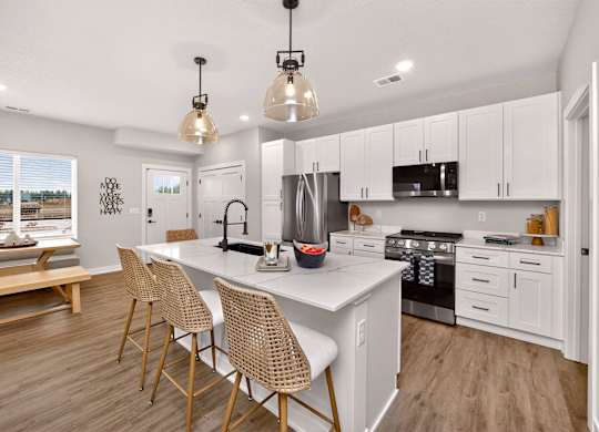 A modern kitchen with white cabinets and a large island.