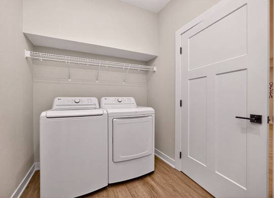 A white laundry room with a washer and dryer.