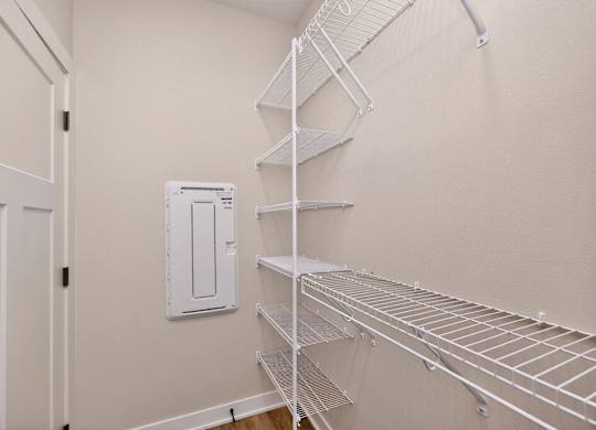 A white metal shelving unit in a room with a white door.