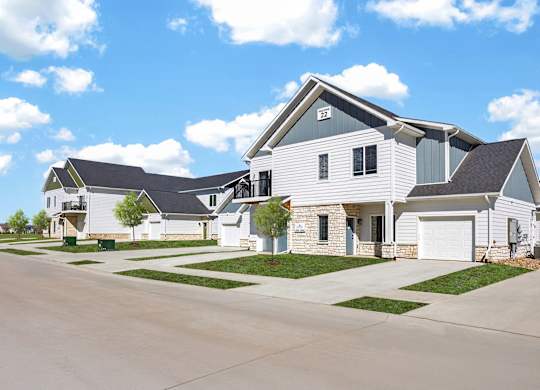 A large white house with a grey roof and a garage.