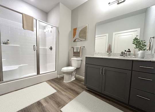 A bathroom with a toilet, sink, and shower.