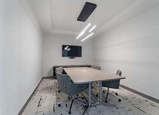 A conference room with a long table and chairs.