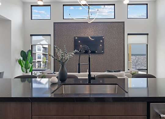 A modern kitchen with a dark brown countertop and a large island.