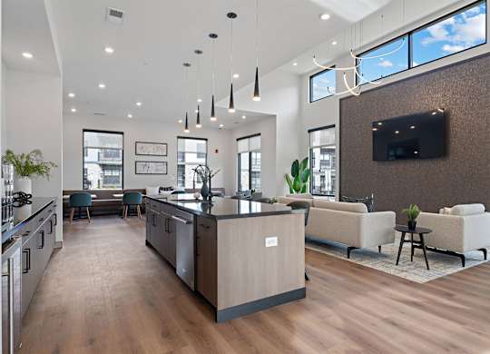 A modern kitchen with a wooden floor and a large island in the middle.
