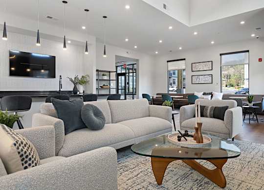 A modern living room with a grey sofa and a glass coffee table.