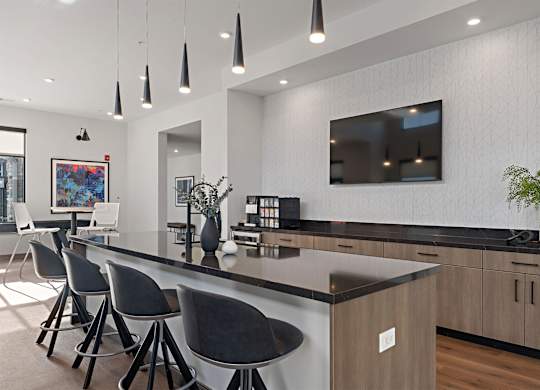 A modern kitchen with a bar area and chairs.